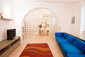 a living room with a blue couch and a tv at Appartamento La Cittadella in Piombino