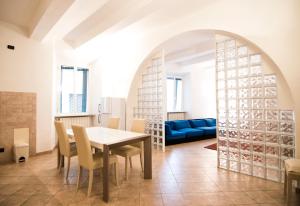 a dining room with a table and chairs and a blue couch at Appartamento La Cittadella in Piombino