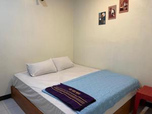 a bed in a room with a towel on it at Rara Guest House Raja Ampat in Pulau Saonek-kecil +13 photos