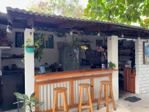 a bar with two stools under a pergola at Casa Rockot in Puerto Escondido