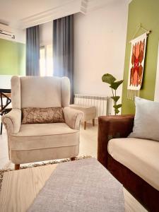 a living room with a chair and a couch at Havre de paix au centre de la marsa in La Marsa +20 photos