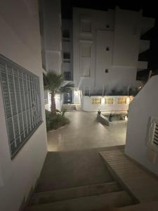 a night view of a building with a palm tree at Casa de Yassine in Hammamet Nord