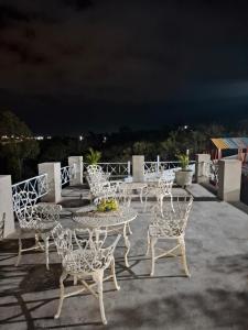 a group of chairs and a table on a patio at night at Pousada Chalés da Serra in Cuité