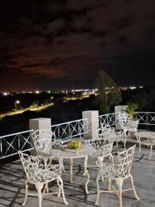 a table and chairs on a patio at night at Pousada Chalés da Serra in Cuité