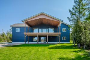 a blue house with a wooden roof at Luxury Lakefront Escape W Games Room in Stokes Bay
