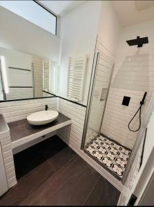 a white bathroom with a sink and a shower at Luitpold Hotel in Nürnberg