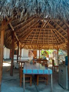 a wooden table under a thatched roof at Ova Baluk Bungalow in Nembrala