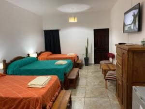 a hotel room with two beds and a tv at Esquina Lodge in Esquina