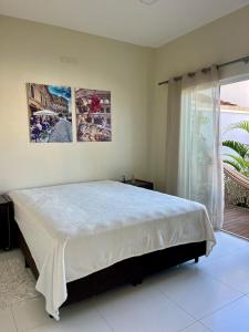 a bedroom with a large bed and a window at MarisC&LHouse 1- Quarto casal in Bombinhas
