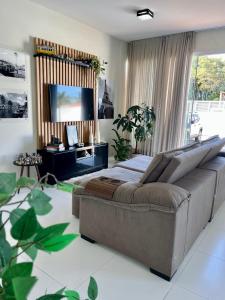 a bedroom with a large bed and a couch at MarisC&LHouse 1- Quarto casal in Bombinhas +13 photos