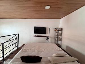 a bedroom with a bed and a flat screen tv at Guaduas apartaestudio Angel de la Villa in Guaduas +8 photos