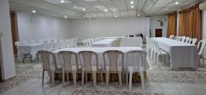 una sala de conferencias con mesas blancas y sillas blancas en Hotel Tame Real, en Tame