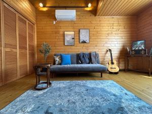 un soggiorno con un divano e una chitarra di 草枕 -kusamakura- private stay a Tomakomai