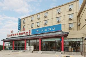 a building with a blue sign in front of it at 汉庭固安北京大兴国际机场酒店 in Dongsunguo
