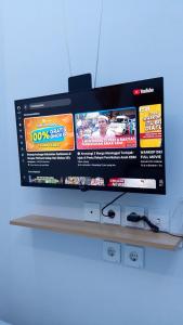 a flat screen tv hanging on a wall at Laswi Syariah Guest House in Bandung