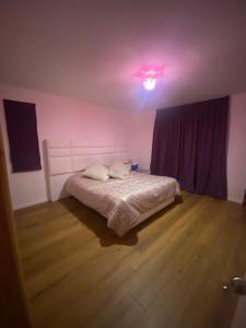 a bedroom with a bed and a pink light at Casa Villarrica, villa los Chilcos in Villarrica
