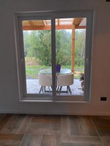 a room with a window with a table and a view at Casa Villarrica, villa los Chilcos in Villarrica