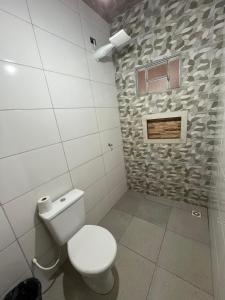 a bathroom with a toilet and a stone wall at Cantinho da Herança in Pirenópolis