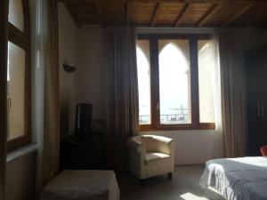 a bedroom with a bed and a chair and a window at Cala Dei Mori in Livorno