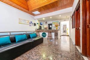 a living room with a black couch and a bar at Hotel Marlon in Villavicencio