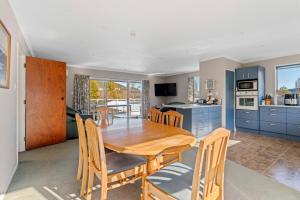 a kitchen and dining room with a wooden table and chairs at Kinloch Family Retreat - Kinloch Holiday Home in Kinloch