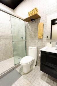 a bathroom with a toilet and a glass shower at 505 Heart of CDMX 1Bdrm 1bath apt AC Rooftop in Mexico City