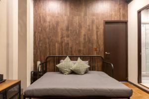 a bed with two pillows on it with a wooden wall at 505 Heart of CDMX 1Bdrm 1bath apt AC Rooftop in Mexico City