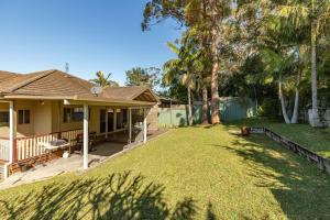 a house with a large yard with a yard at Follow The Sun in Smiths Lake