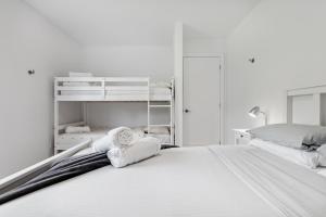 a white bedroom with a bed and bunk beds at Chalet MoCo in Saint Come