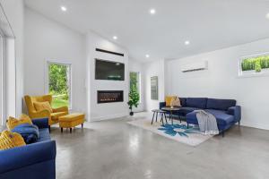 a living room with blue couches and a tv at Chalet MoCo in Saint Come