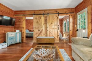 a living room with wooden walls and a sliding door at Maine Coastal Cottage in Wells