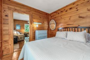 a bedroom with a bed in a room with wooden walls at Maine Coastal Cottage in Wells
