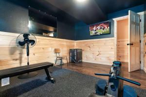 une pièce avec une salle de sport avec une télévision au mur dans l'établissement Relax and Recharge Sauna Hot Tub and Gym, à Sevierville
