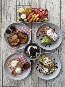 a table with four plates of food and fruit at The Charles in Wagga Wagga
