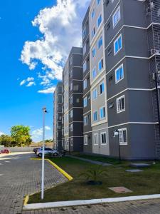 a tall building with a car parked in a parking lot at Apartamento de 02 quartos com vista para o lago in Palmas