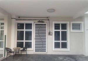 a patio with chairs and a table in front of a house at Putera homestay in Juasseh