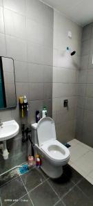 a bathroom with a toilet and a sink at Putera homestay in Juasseh +7 photos