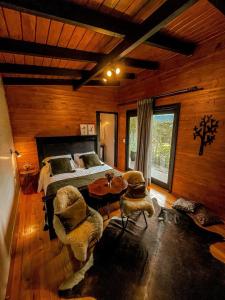 a bedroom with a bed and a table and chairs at La Serena Cabanas in Urubici