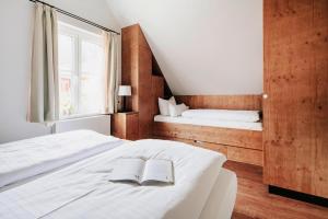 une chambre avec deux lits et un livre sur le lit dans l'établissement Ferienhäuser im Torfhaus Harzresort, Torfhaus, à Torfhaus