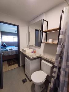 a bathroom with a toilet and a sink and a mirror at Studio Barreto Leme Ap72 in Campinas