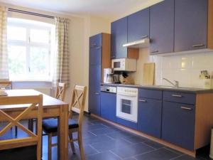 GarzにあるGutshaus Zicker in Garzのキッチン(青いキャビネット、テーブル付)、ダイニングルーム