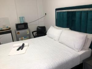 a bedroom with a bed with a remote control on it at Duminy House Guest Lodging in Bellville