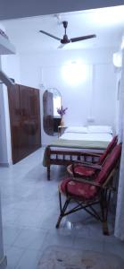 a bedroom with a bed and a mirror and a chair at Alappuzha Family Vacation Villa - LAYANILA in Alleppey