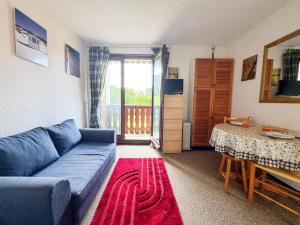 a living room with a blue couch and a table at Appartement au pied des pistes à Bernex avec balcon et parking - FR-1-498-117 in Bernex