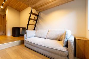 a couch in a living room with a loft bed at Morinest 北軽井沢 Private Spa in Tsumagoi +35 photos