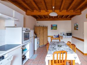 eine Küche mit einem Tisch mit Stühlen und einem Kühlschrank in der Unterkunft Charmant domaine avec 2 gîtes pour 15 pers, animaux admis, wifi, jardin et terrasse - FR-1-496-368 in Les Salles + 15 Fotos