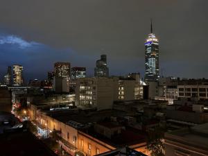 un perfil urbano por la noche con un rascacielos alto en Frida my Loft, en Ciudad de México