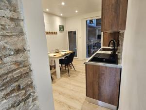 a kitchen with a sink and a table in a room at Maison de ville rénovée avec garage privatif à Épinal - FR-1-589-834 in Épinal