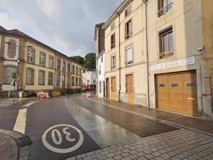 an empty city street with buildings and a sign that saysovo at Maison de ville rénovée avec garage privatif à Épinal - FR-1-589-834 in Épinal
