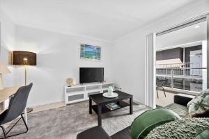 a living room with a couch and a table at Modern Coastal Escape in the Heart of Rockingham in Rockingham